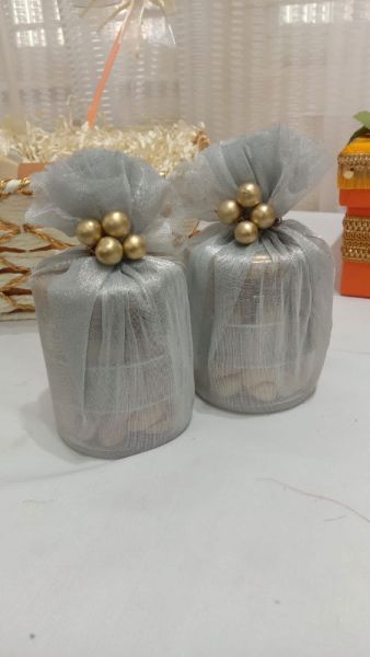 Two gray wrapped presents with gold decorations on a white surface.