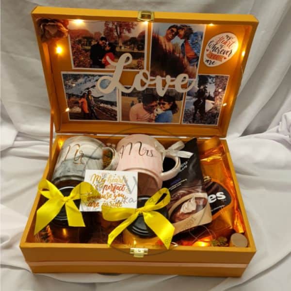 Gift box with 'Mr' and 'Mrs' mugs, chocolates, and a photo collage on a white background.