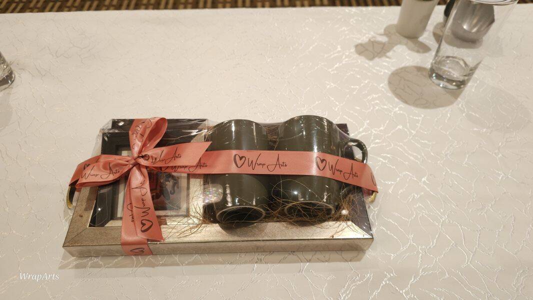 Set of black canisters with a pink ribbon on a white surface