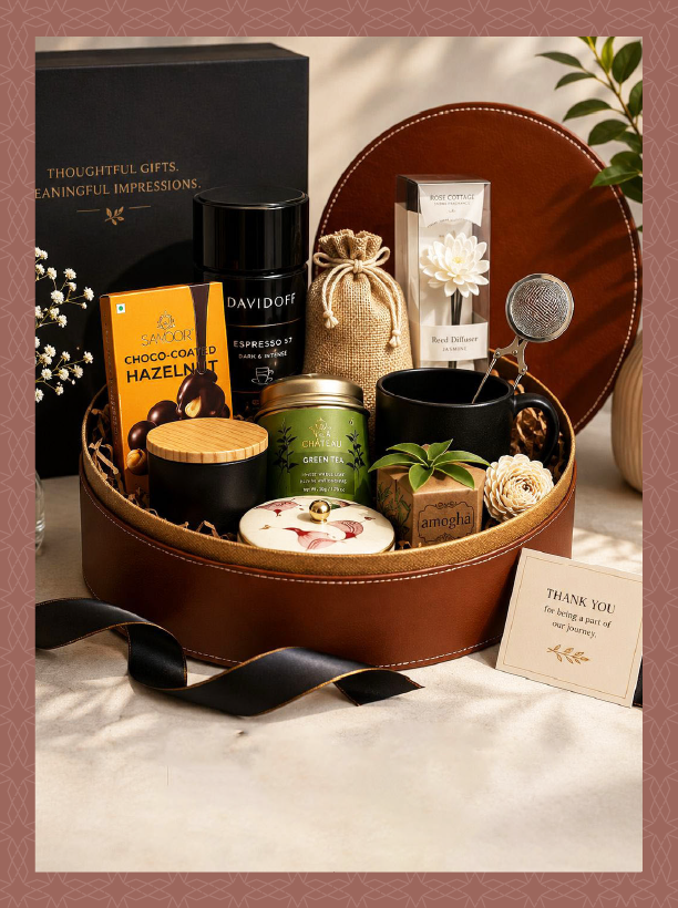 Gift box with black ribbon, black tumbler, and black phone stand on a white background