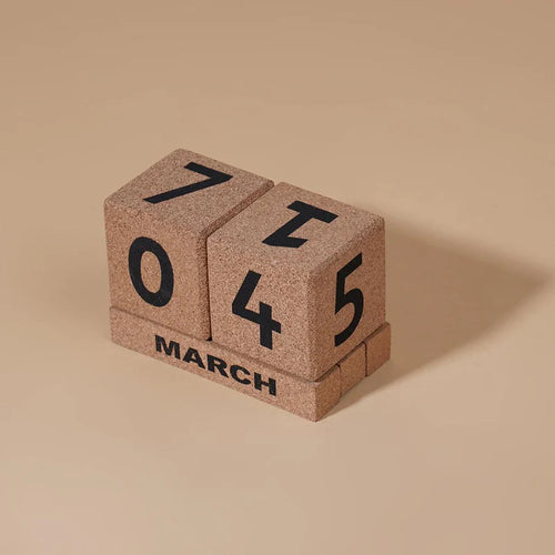Cork calendar block displaying the date '7 March 045' on a beige background