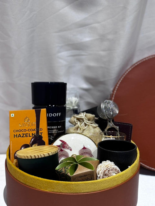 Gift basket with coffee, chocolate, and decorative items on a white background