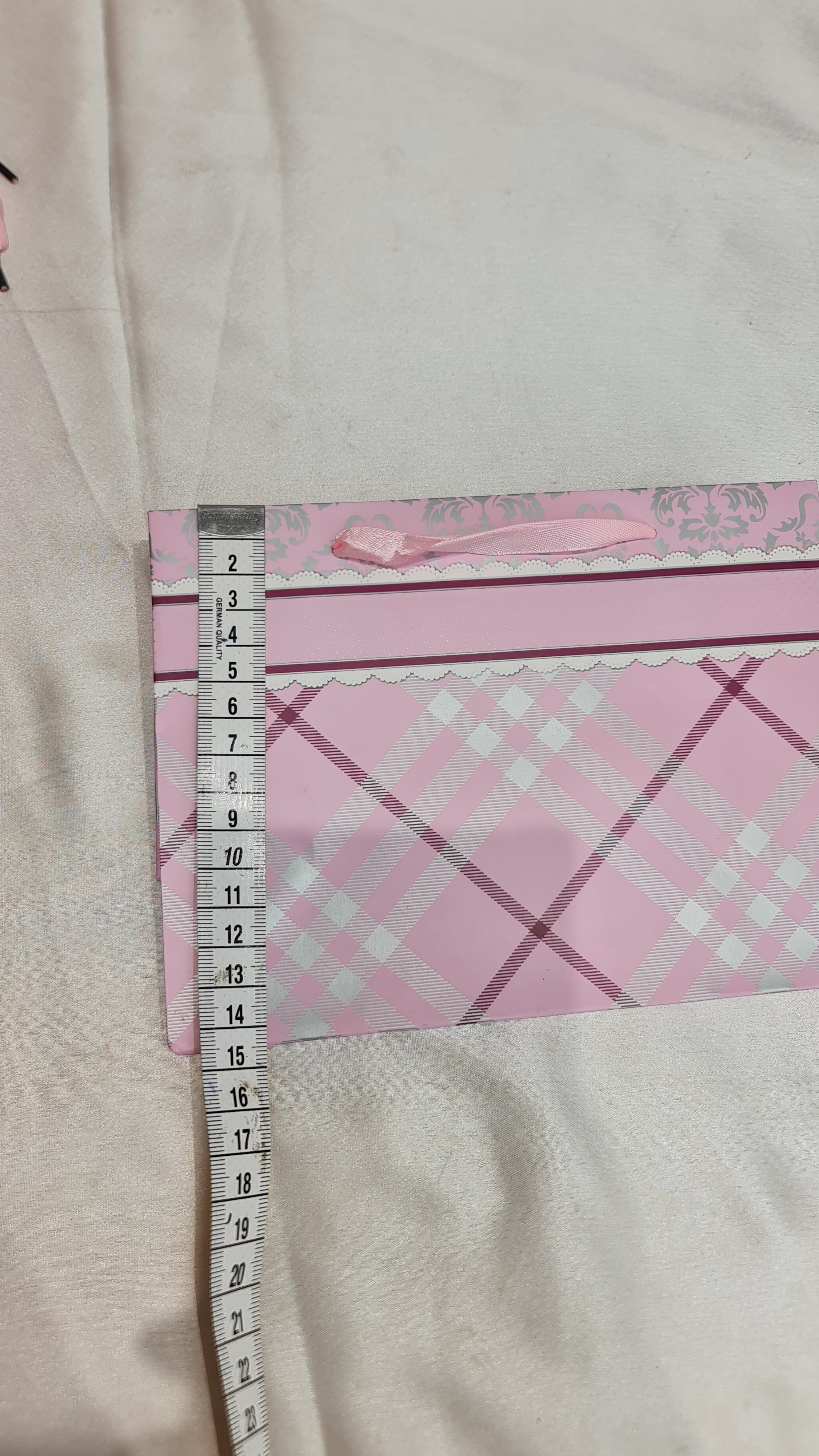 Sheet of paper with pink and white checkered pattern on a light gray background