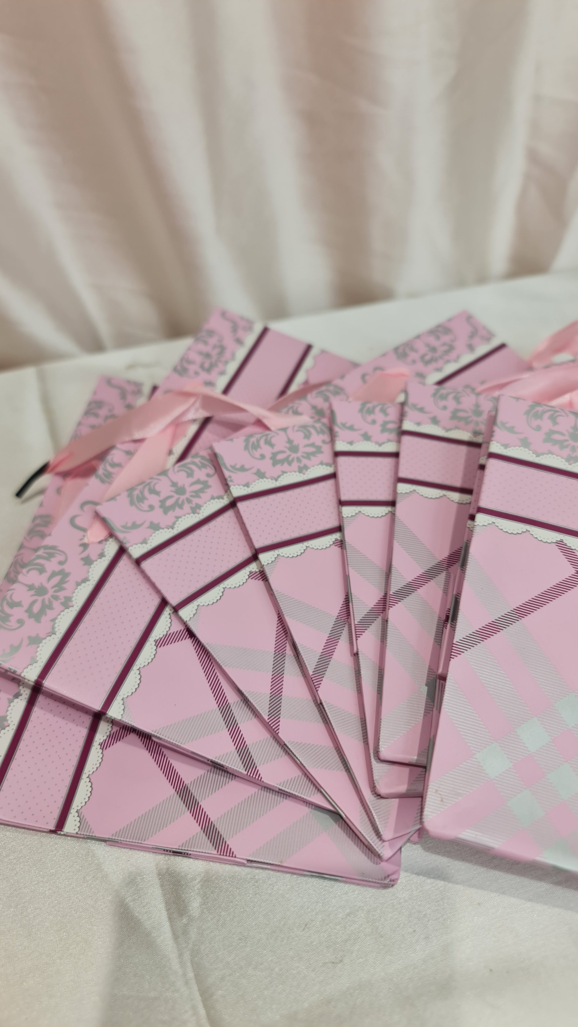 Set of pink and white pajama pants on a light-colored fabric background