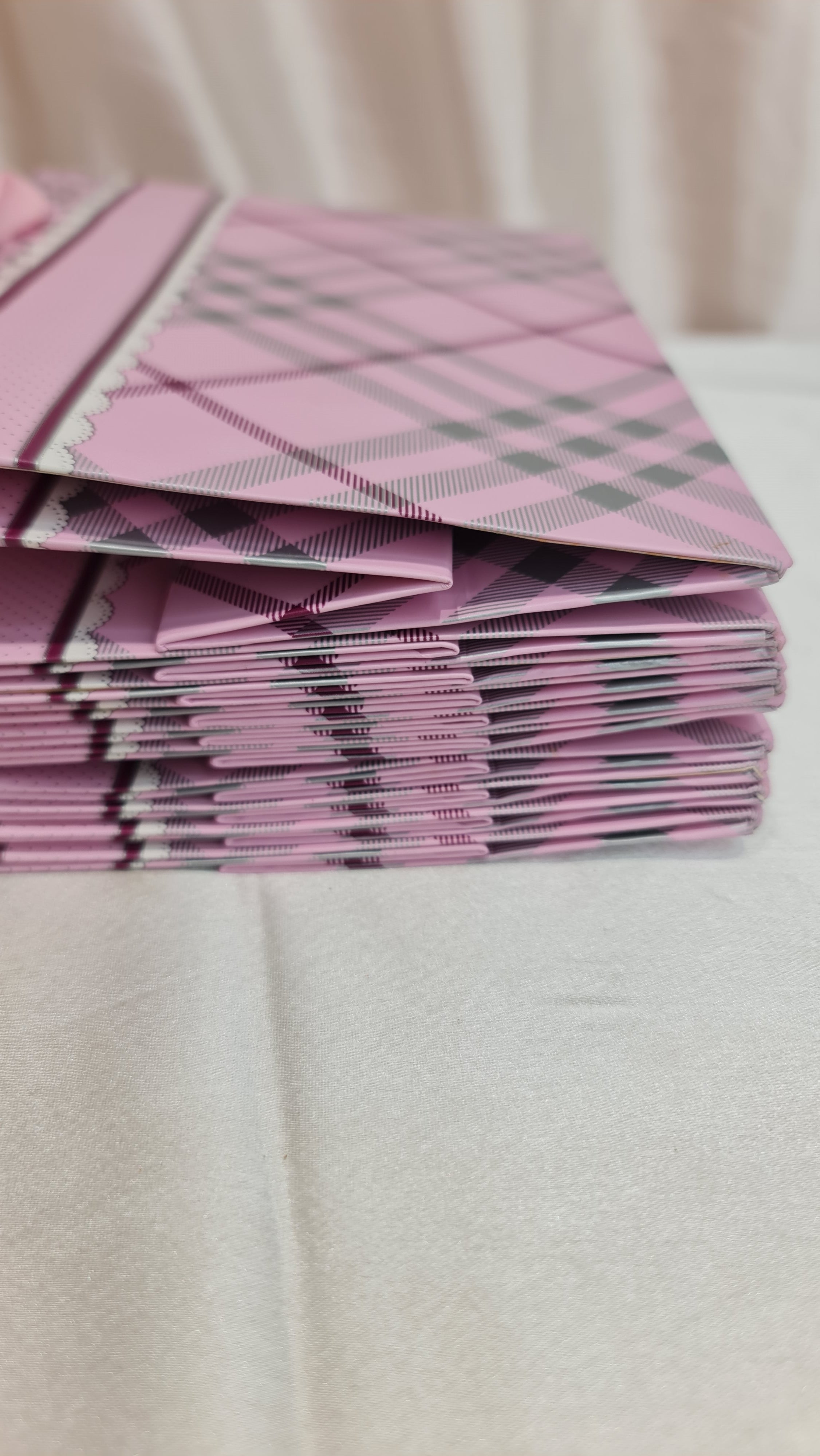 Stack of pink and gray checkered paper on a white surface