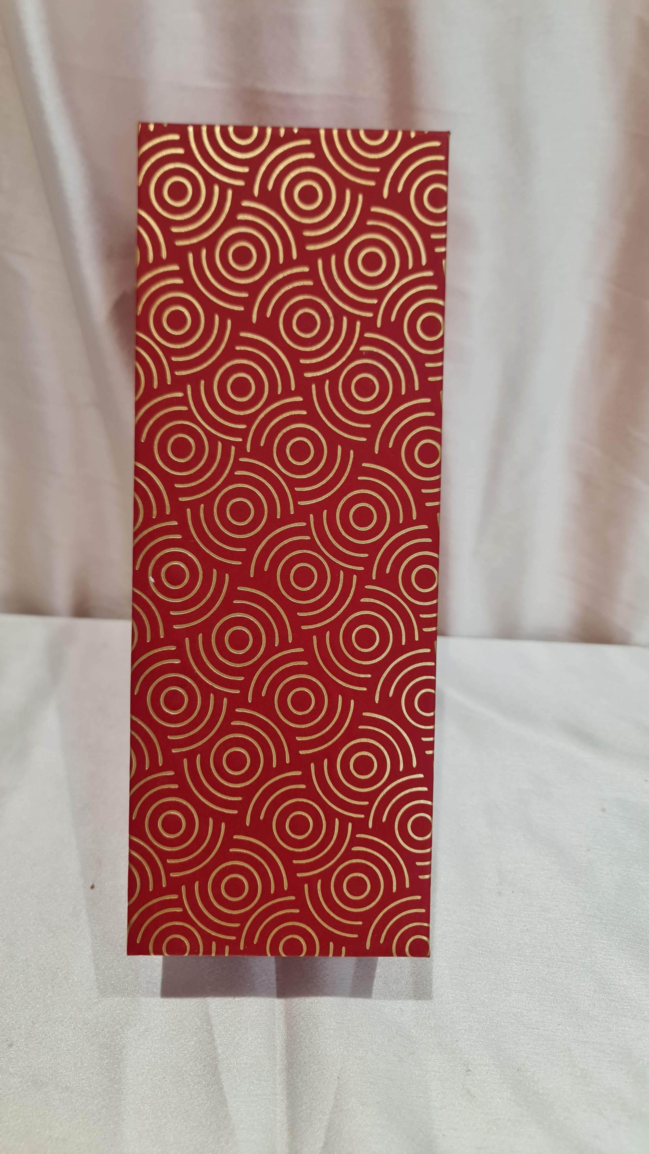Red patterned paper with white circles on a beige background