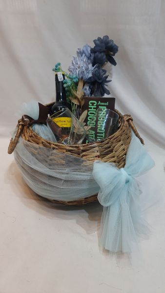 Wicker basket with flowers, bottles, and books on a white background