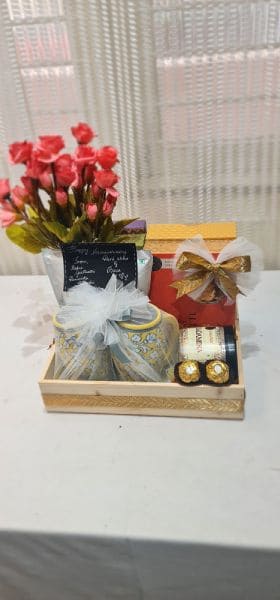 Gift set with flowers, chocolates, and a small truck-shaped box on a white surface.