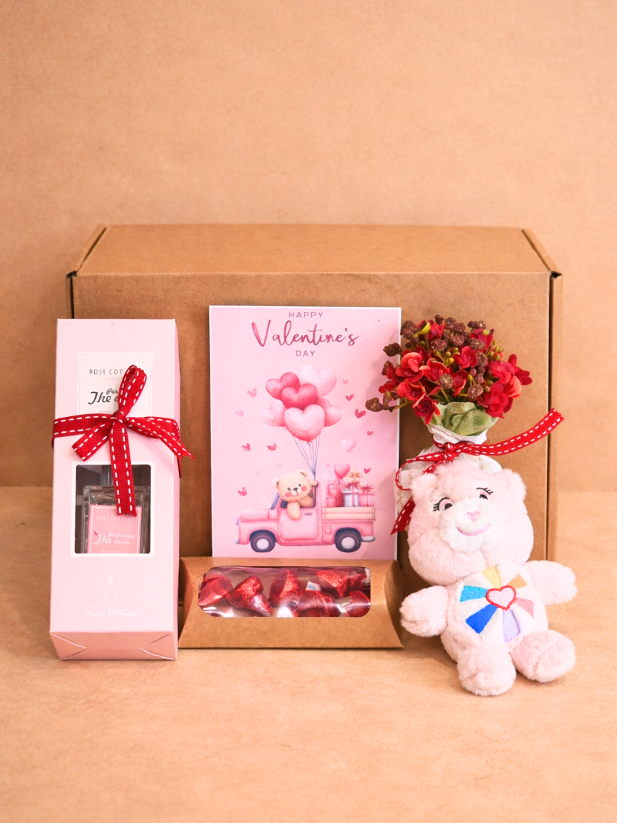Valentine's Day gift set with a plush toy, card, and small plant on a brown background