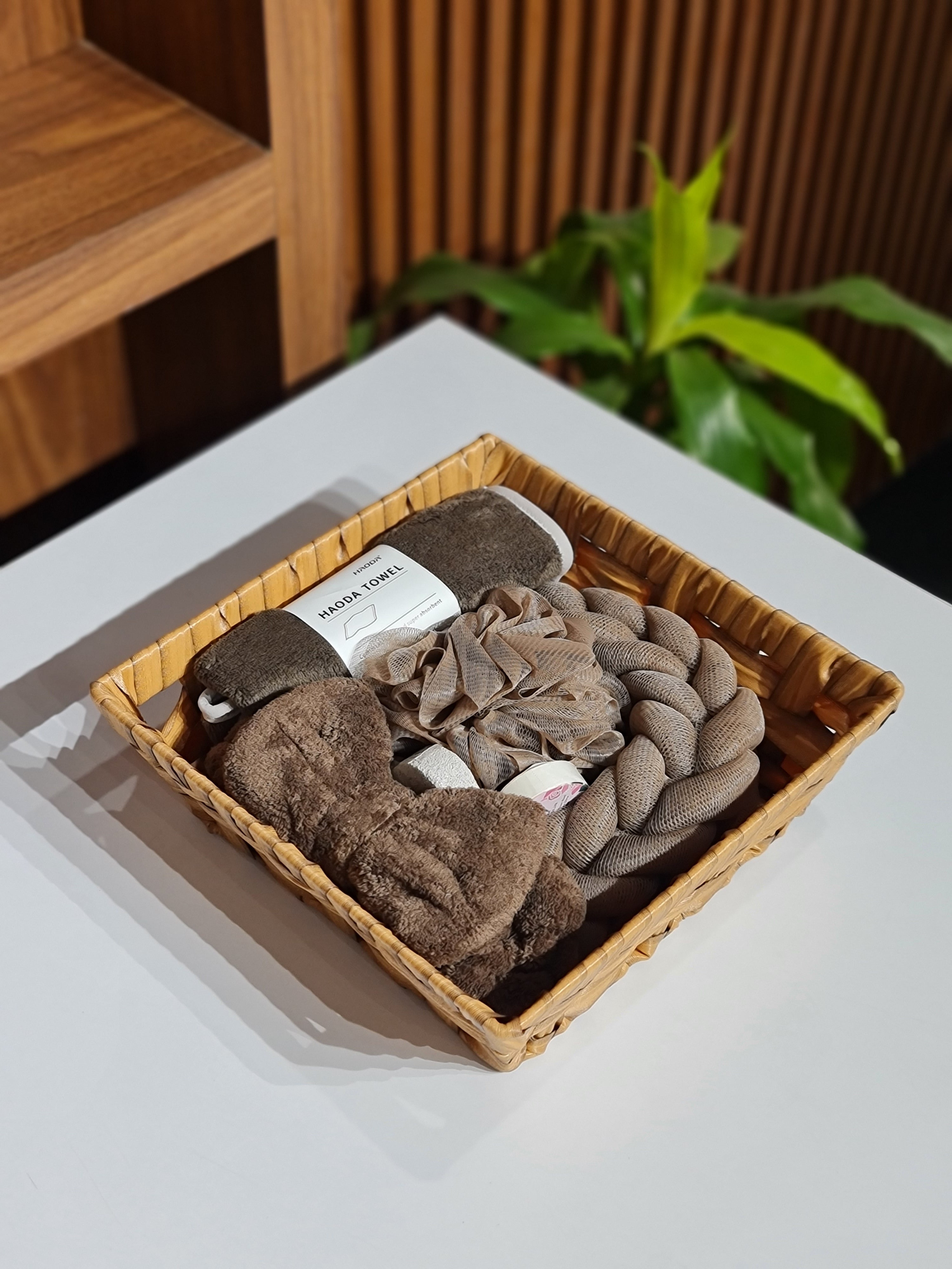 Basket of brown hair ties on a white surface with a blurred plant in the background