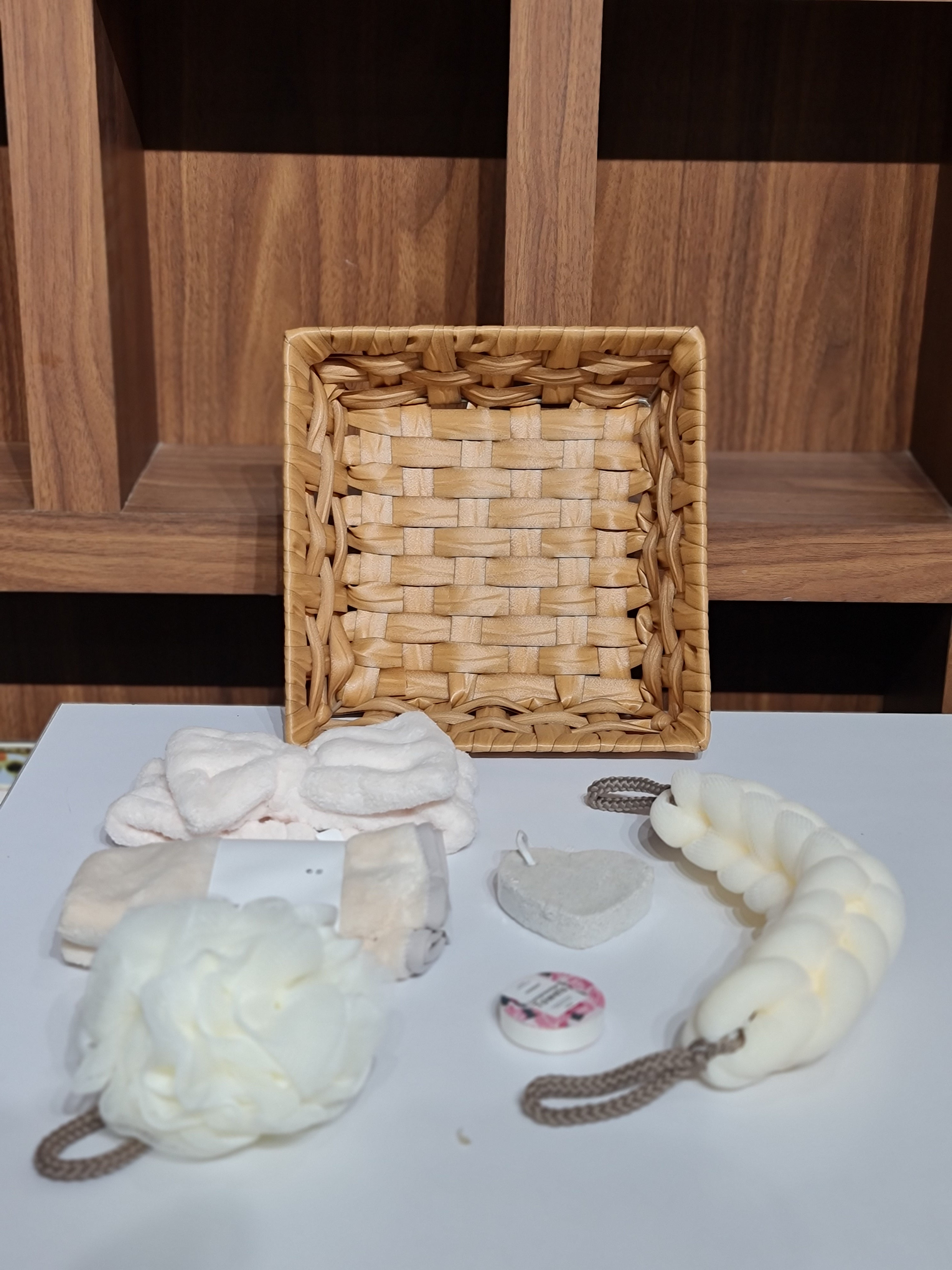 Wooden shelf with a woven basket and decorative items on a white surface