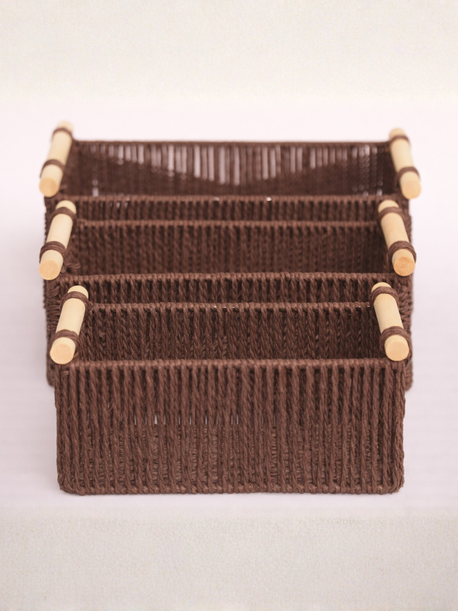 Brown woven basket with wooden handles on a light gray background