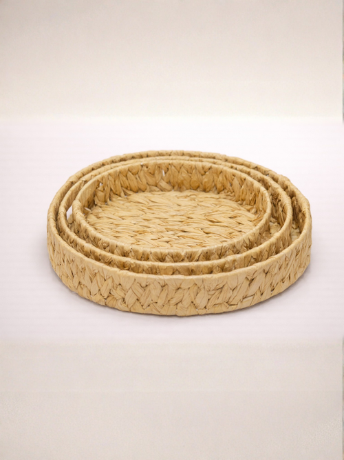 Set of three woven baskets on a light beige background