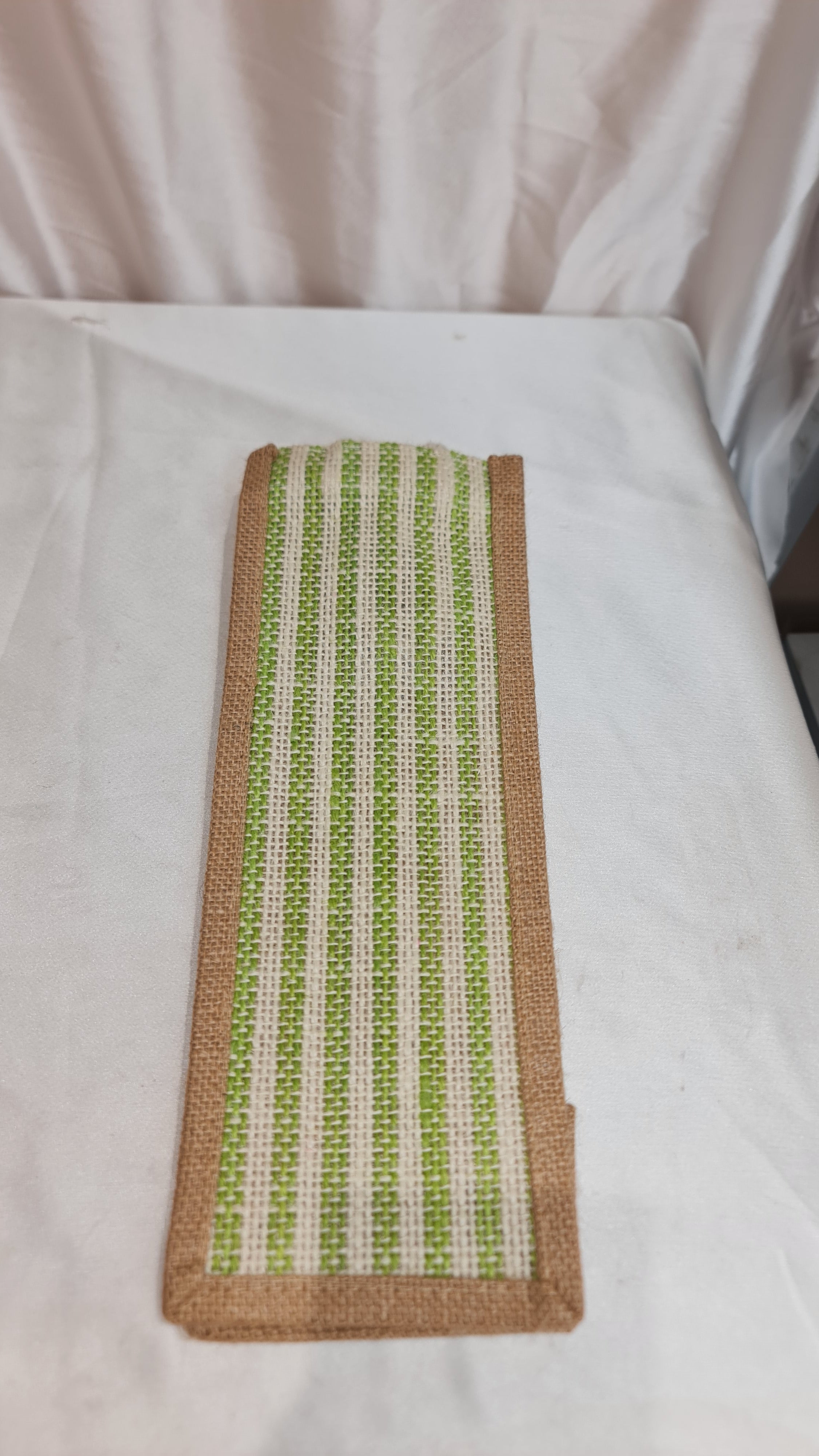 Textile patch with green and brown pattern on a white fabric background