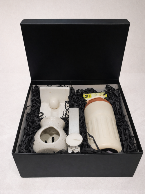 Set of ceramic items including a bottle and a bowl in a black box on a white background