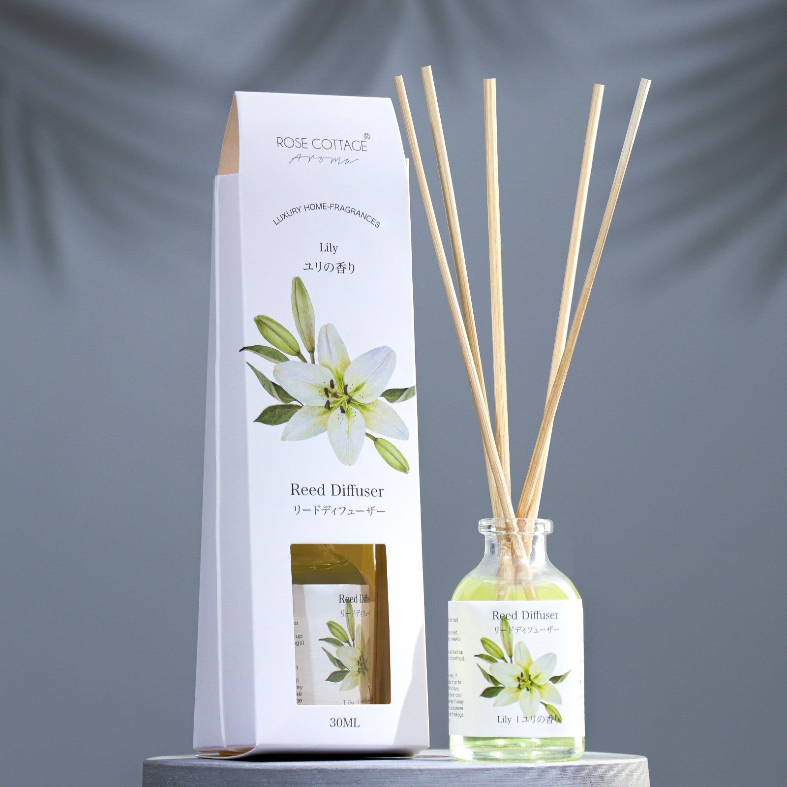 Reed diffuser set with bottle and packaging on a gray background