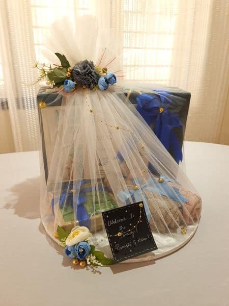 Decorative table centerpiece with flowers and a veil on a white surface.