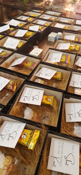 Table with small boxes containing snacks and notes, possibly for a gift or event.