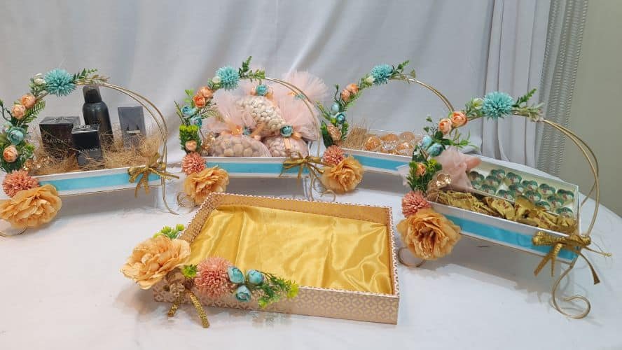 Decorative tray with flowers and a bottle on a white surface